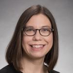 Woman with shoulder length brown hair and eyeglasses. 